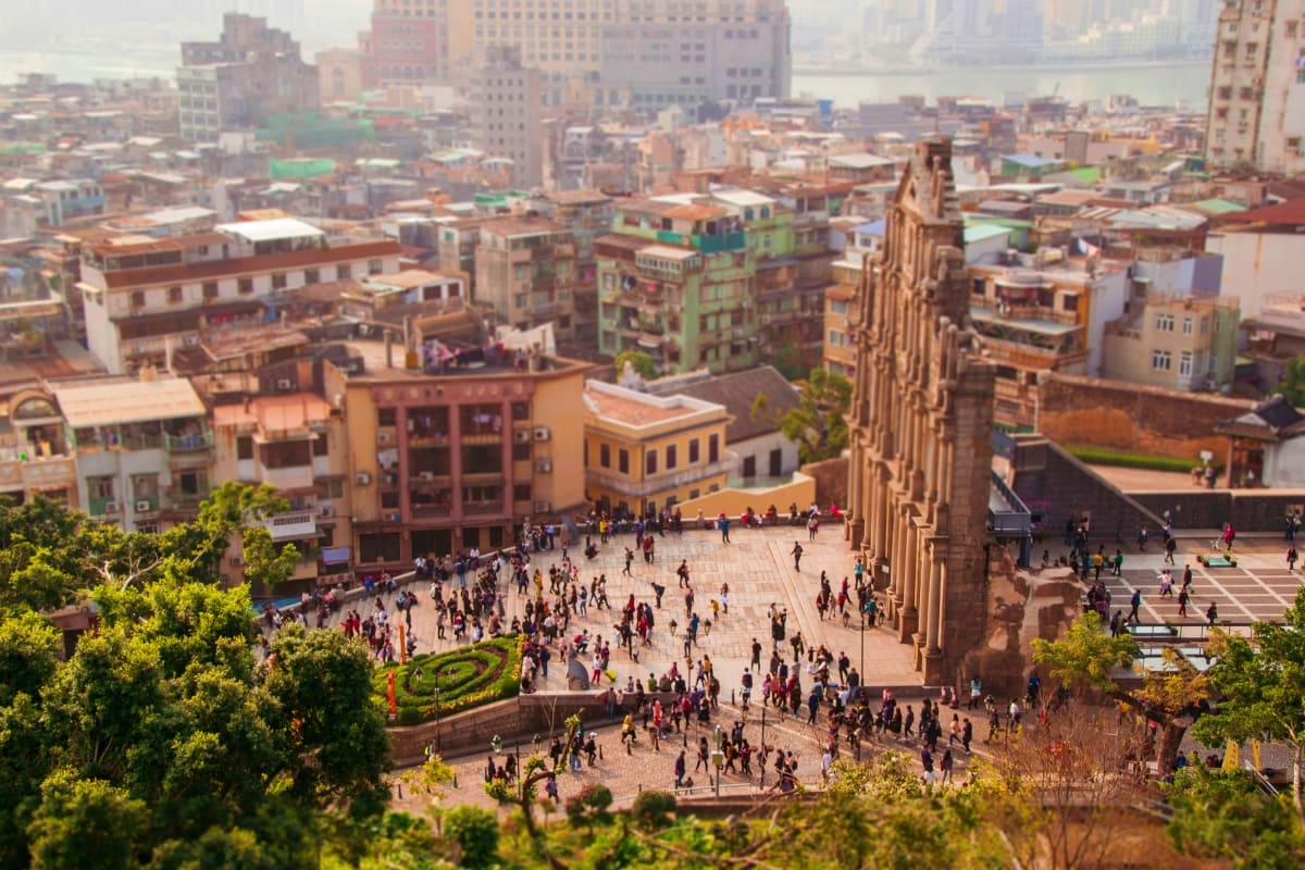 Aerial view of a bustling public square with historic architecture and crowds of people in Shanghai's urban landscape with ri