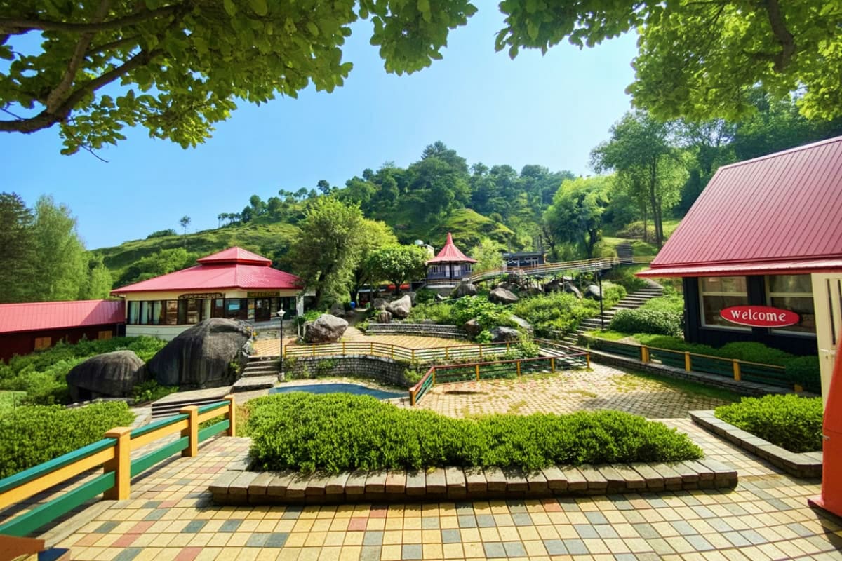 Scenic mountain resort with red-roofed pavilions, manicured gardens, stone pathways, and lush green hills in background under