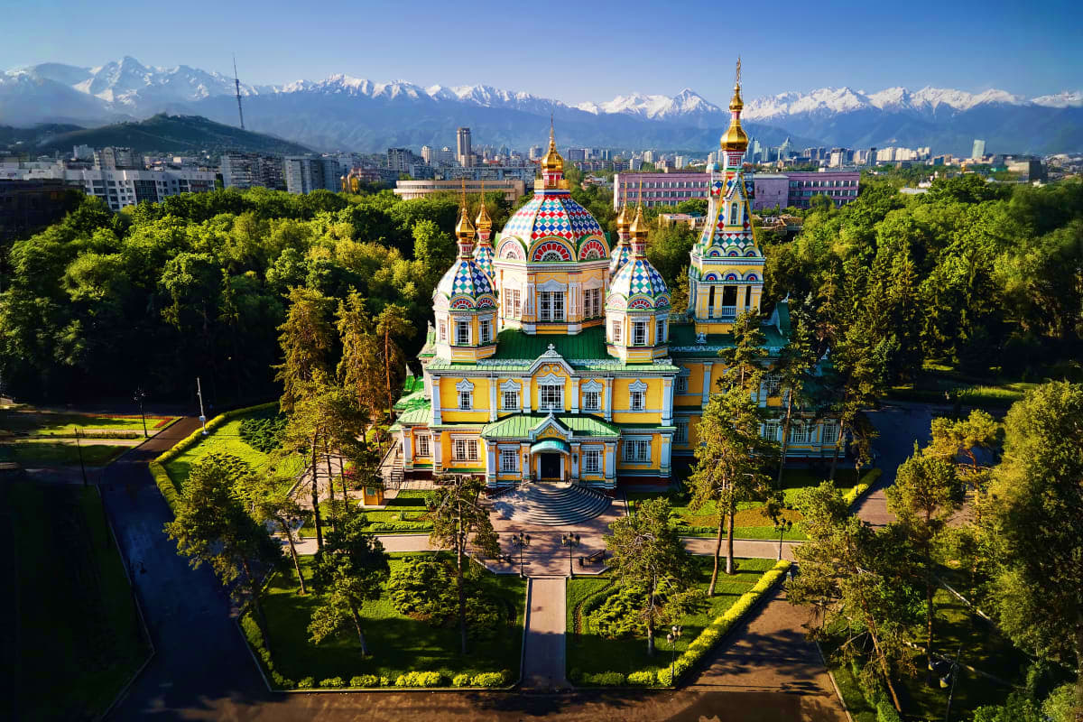 Best of Kazakhstan Aerial view of Saint Panteleimon Orthodox Cathedral with golden domes and colorful architecture, surrounded by green forest a