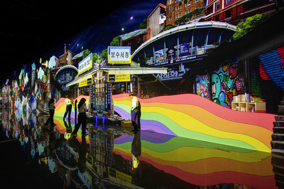 Arte Museum Dubai Colorful rainbow light installation at night in Korean street market with traditional architecture and storefronts