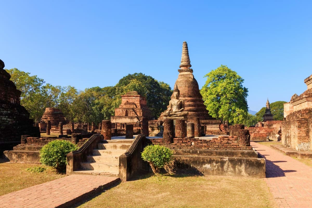 Ayutthaya Full Day Tour Ancient Buddhist temple ruins with brick stupas and sitting Buddha statue in Ayutthaya, Thailand historical park