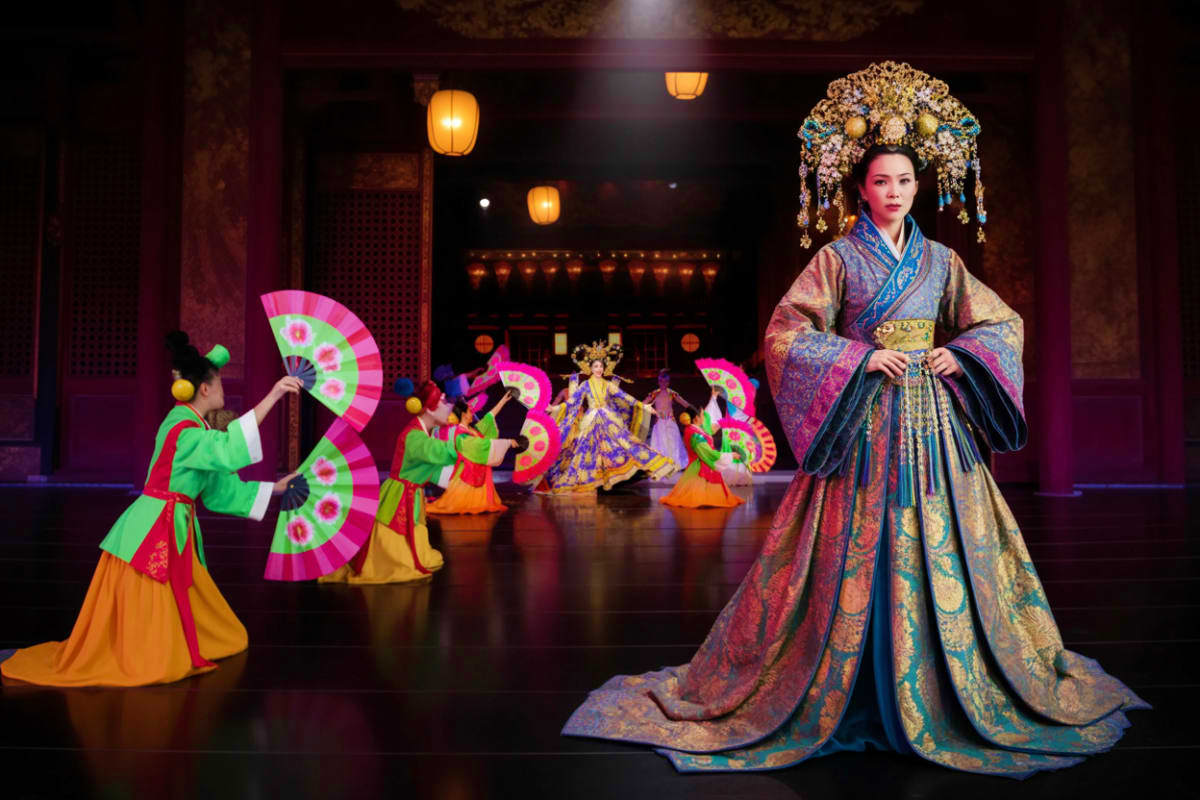 Tiffany Show Pattaya Woman in elaborate traditional Chinese court costume with ornate headdress and flowing robes standing on stage with performer