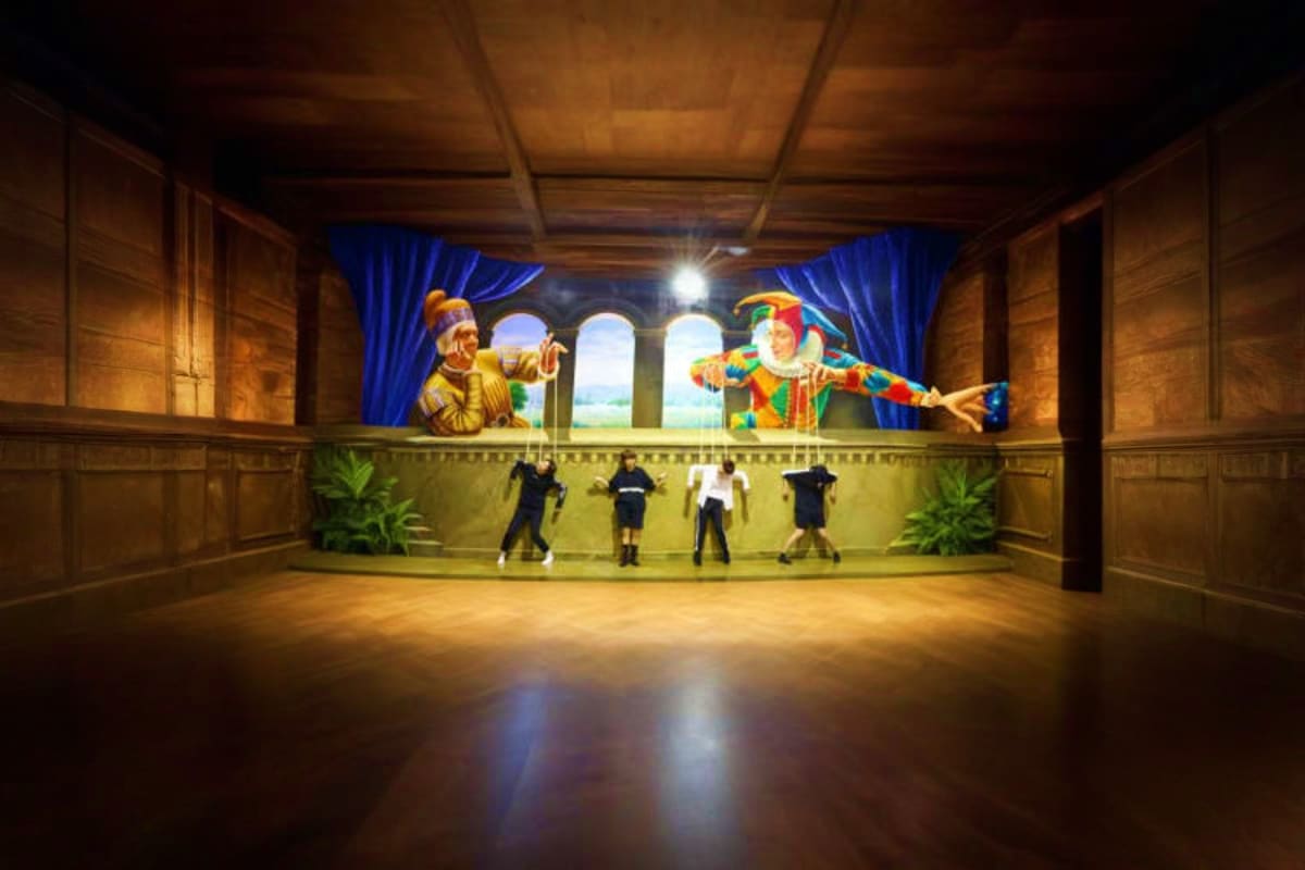 Art in Paradise Group of visitors posing in front of colorful 3D street art mural of Renaissance jesters in elegant wooden hall with blue cur