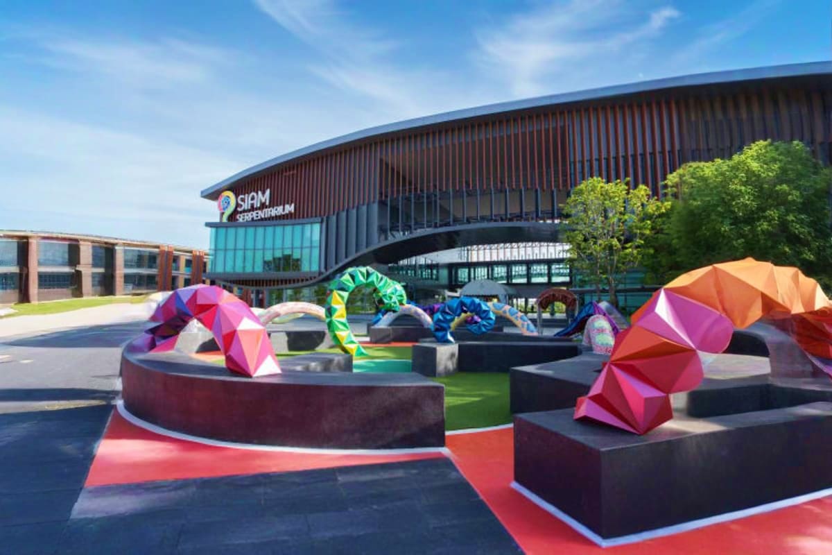 Siam Serpentarium Colorful geometric sculptures in plaza outside Siam Serpentarium building with curved architecture and turquoise entrance