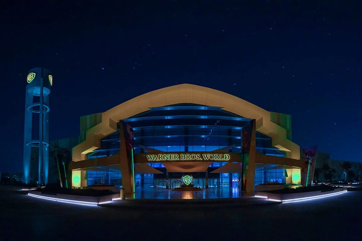 Warner Bros World Abu Dhabi entrance illuminated at night with curved architecture and blue lighting
