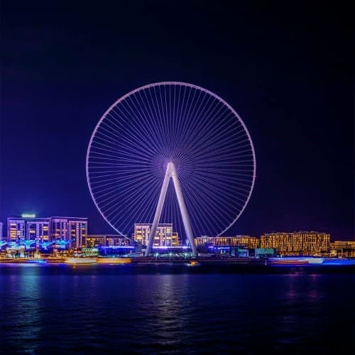 Ain Dubai Observation Wheel Ain Dubai observation wheel illuminated at night with waterfront buildings reflected in calm water below
