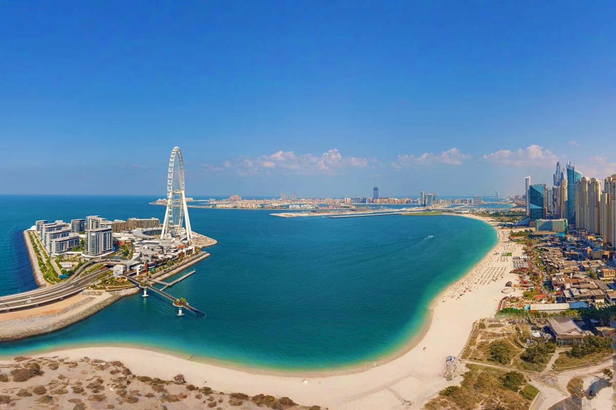Aerial view of Ain Dubai observation wheel and surrounding beaches with turquoise water and Dubai skyline