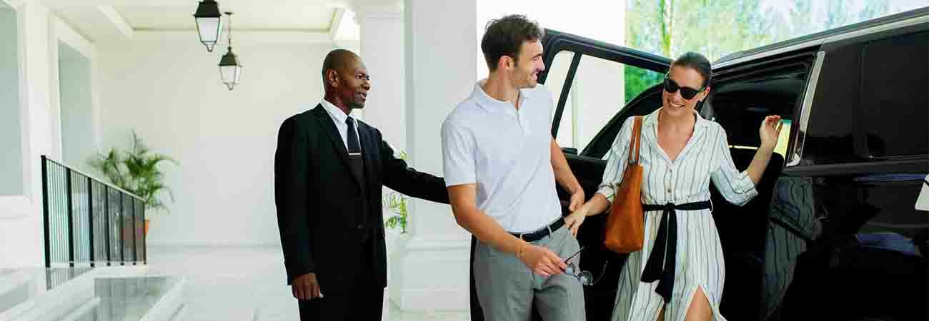 Dammam Intercity Transfers Professional driver greeting couple arriving at luxury vehicle for airport transfer service