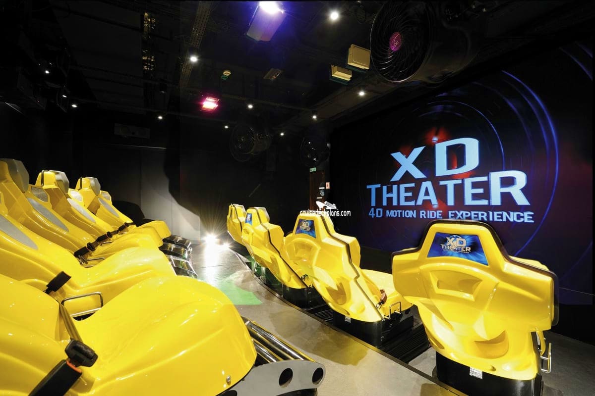 XD Theater 4D motion ride experience with bright yellow motion simulator seats inside dark venue with blue signage