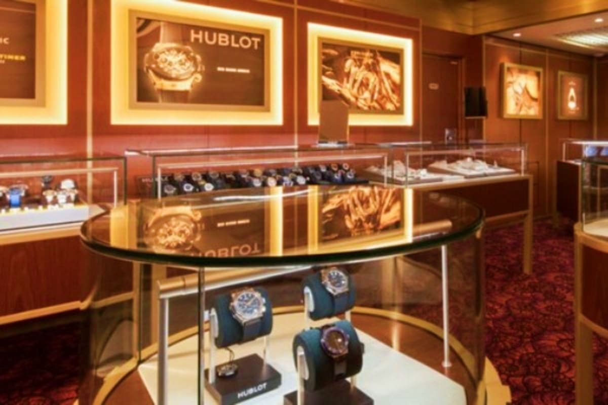 Magical Asia Cruise Escape Hublot luxury watch boutique interior with illuminated displays, glass cases, brown wood paneling, and watches on pedestals