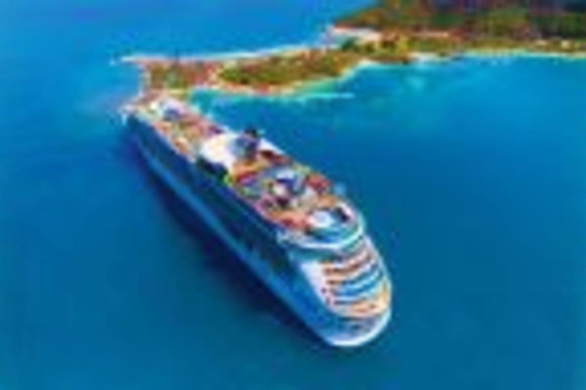 Aerial view of Navigator of the Seas cruise ship anchored in turquoise waters near a tropical coastline with beaches and vege