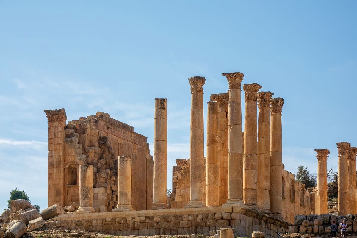 Jordan Amman Classic Tour Package Ancient Roman ruins with standing stone columns and ornate capitals against blue sky in Jerash, Jordan