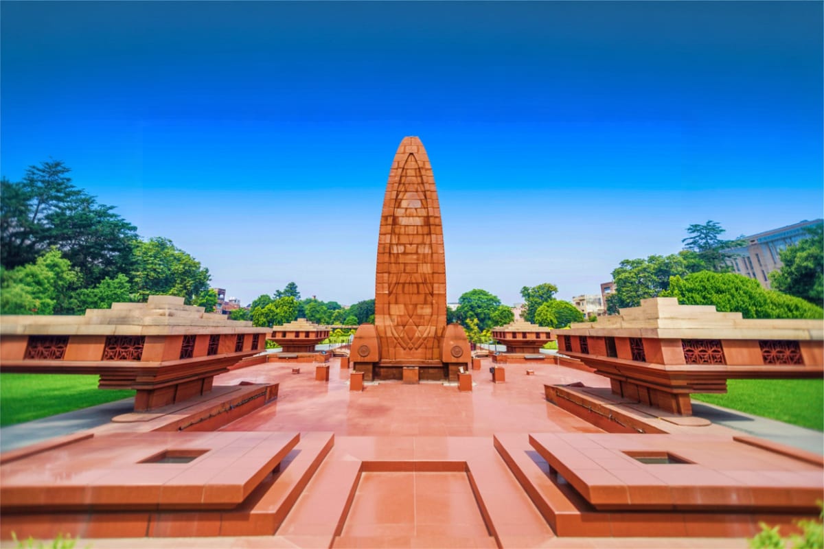 Amritsar Highlights Tour with Temples History and Border Retreat Jallianwala Bagh memorial with tall obelisk monument, red brick walls, and manicured lawns in Amritsar, India