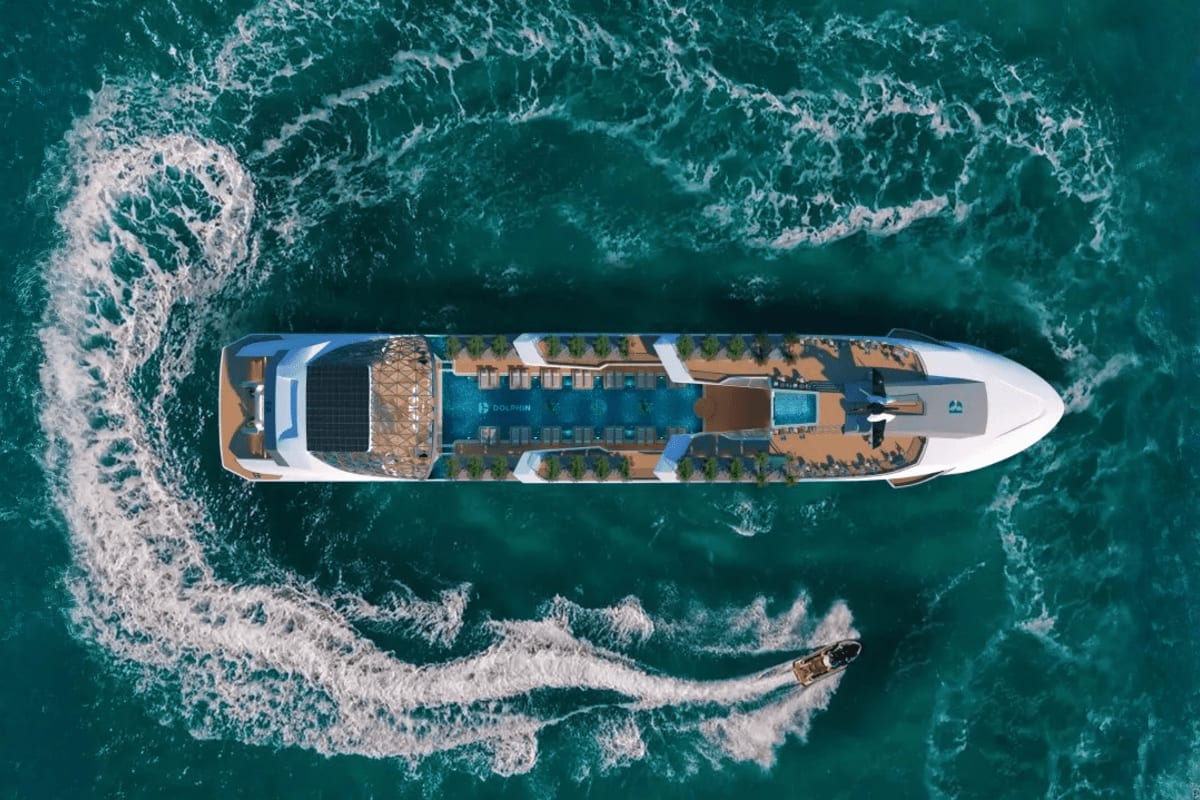 Aerial overhead view of Dolphin luxury cruise ship surrounded by turquoise ocean waves with white foam patterns