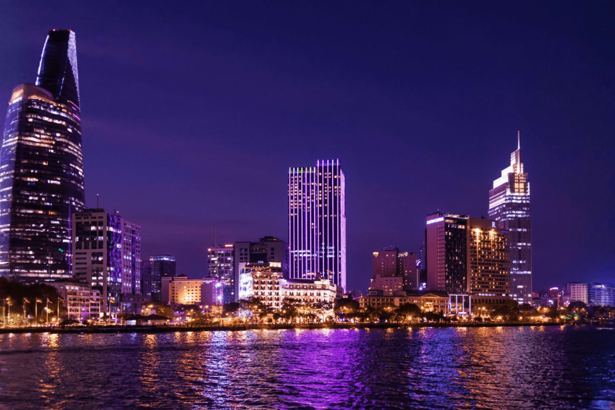 Ho Chi Minh Full day Private Tour Ho Chi Minh City skyline at night with illuminated buildings reflected in the Saigon River