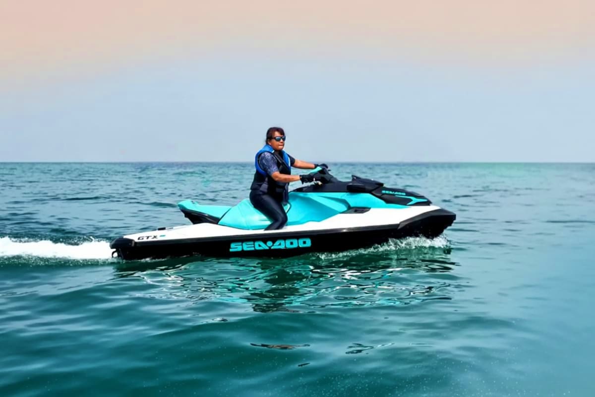 Jet Ski at Cenang Beach Man riding a turquoise and white Sea-Doo jet ski on calm ocean waters at Cenang Beach