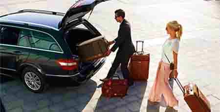 Jeddah Airport DropOff Man and woman loading luggage into car trunk at airport drop-off zone