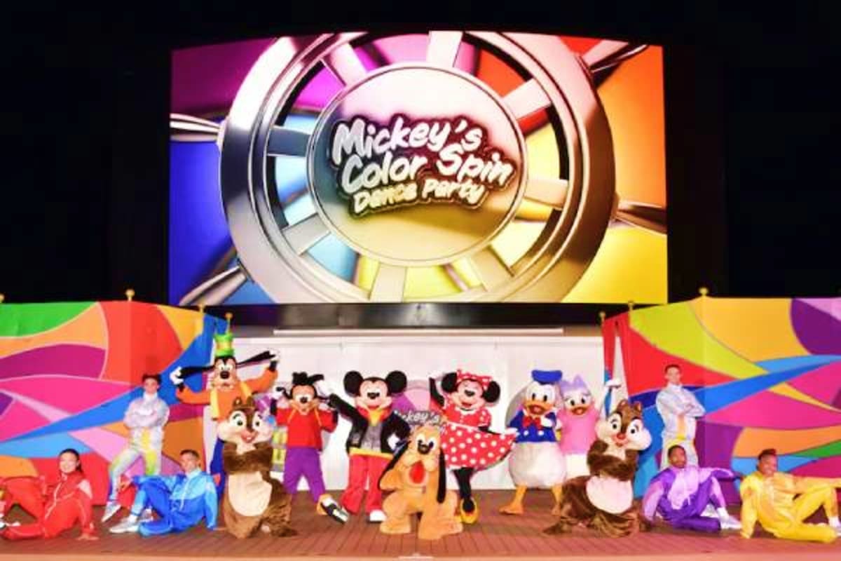 Mickey's Color Spin Dance Party stage show with Disney characters and colorful wheel display on cruise ship theater screen
