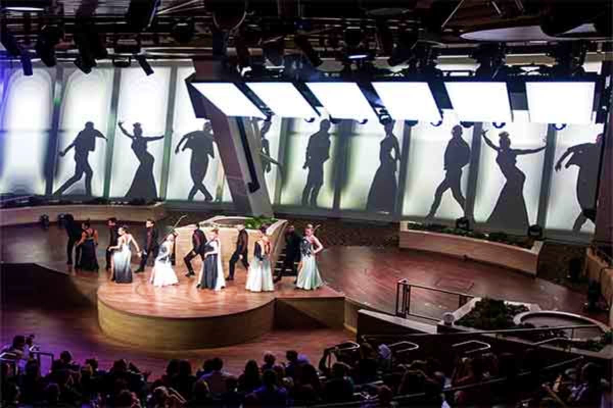Performers in formal attire on stage during an entertainment show aboard Independence of the Seas cruise ship