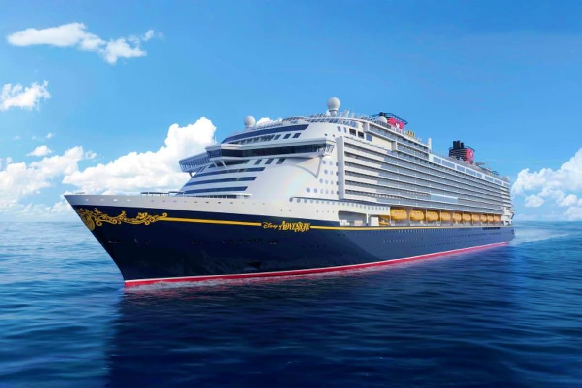 Four Nights Singapore and Langkawi Escape Disney Adventure cruise ship sailing on calm blue ocean waters with clear sky and white clouds