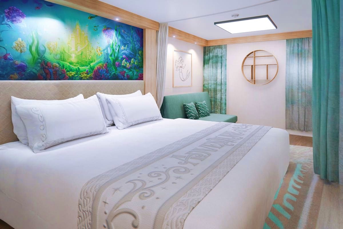 Four Nights Singapore and Langkawi Escape Luxury cruise ship cabin with queen bed, white linens, underwater-themed mural headboard, green accent furniture, and modern