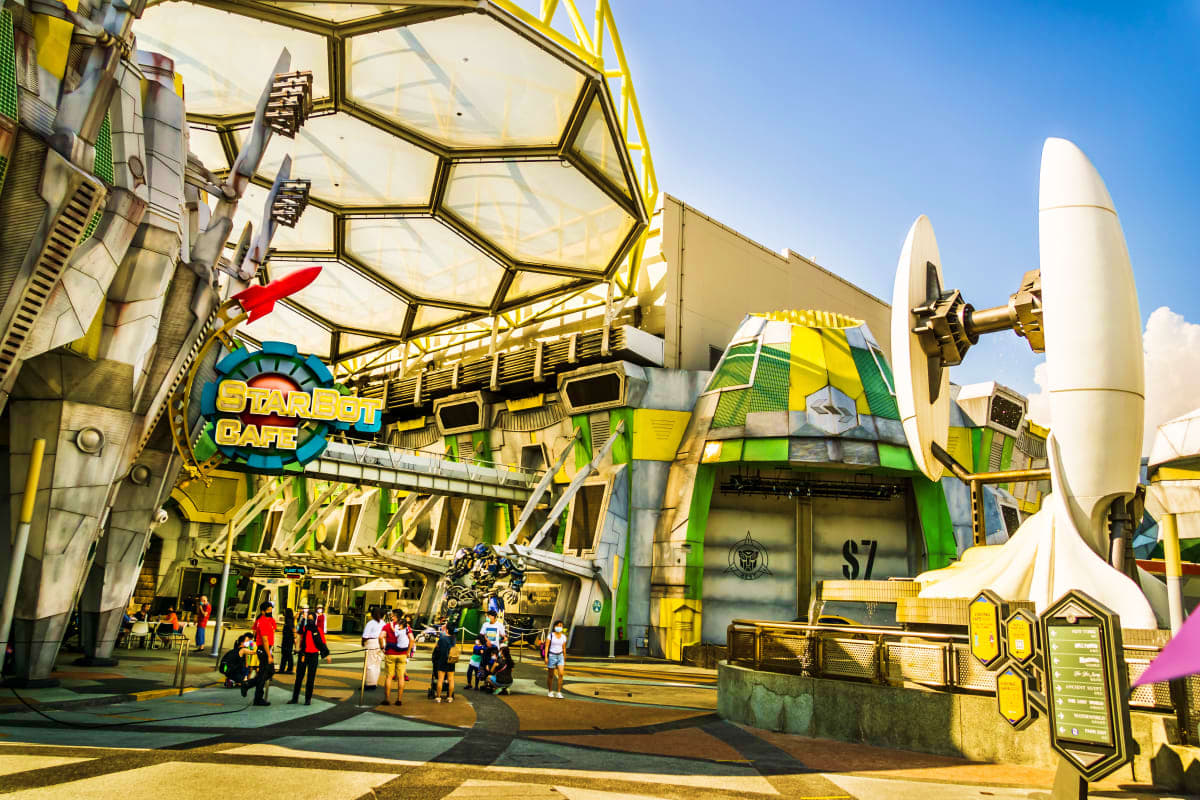 Sentosa Island & City Escape Star Wars Cafe entrance at Sentosa Island theme park with yellow and green futuristic architecture and visitors exploring the