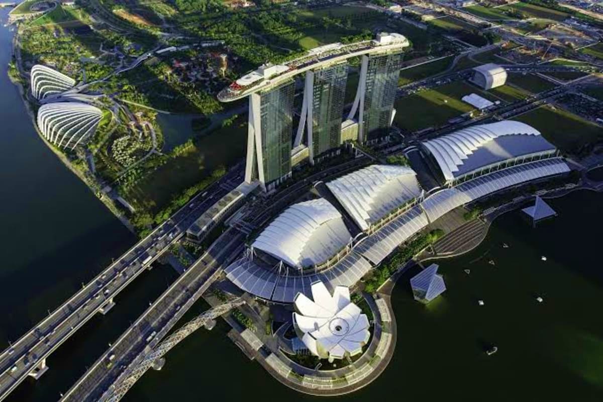 Casino Luxe Aerial view of Marina Bay Sands resort with distinctive architecture, botanical gardens, and waterfront in Singapore