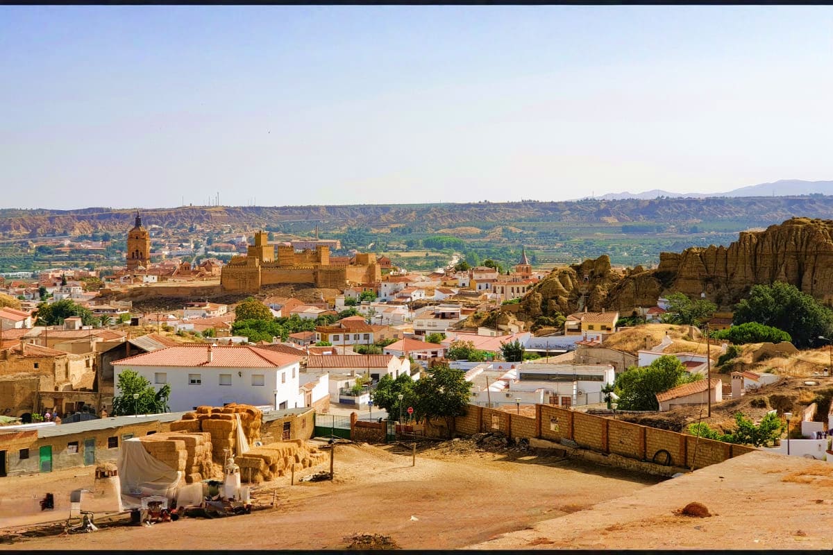 Panoramic view of Tlemcen, Algeria with historic kasbah fortress, white-walled buildings, and rocky outcrops in arid landscap