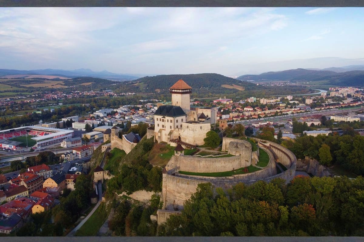 Aerial view of Dunajec Castle in Niedzica, Poland, perched on a hilltop above the Dunajec River Gorge with surrounding forest