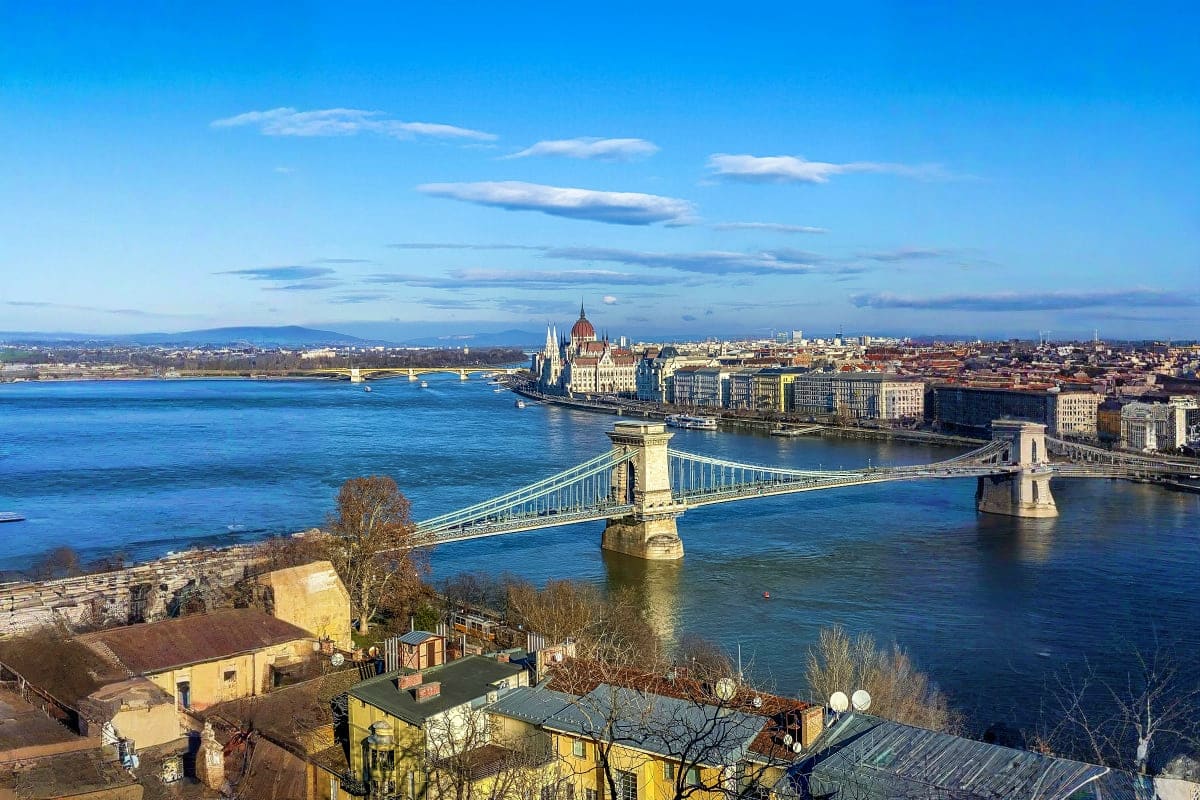 Family tour of Europe From Budapest to Paris Budapest cityscape with Chain Bridge spanning Danube River, Parliament Building, and cityscape under blue sky