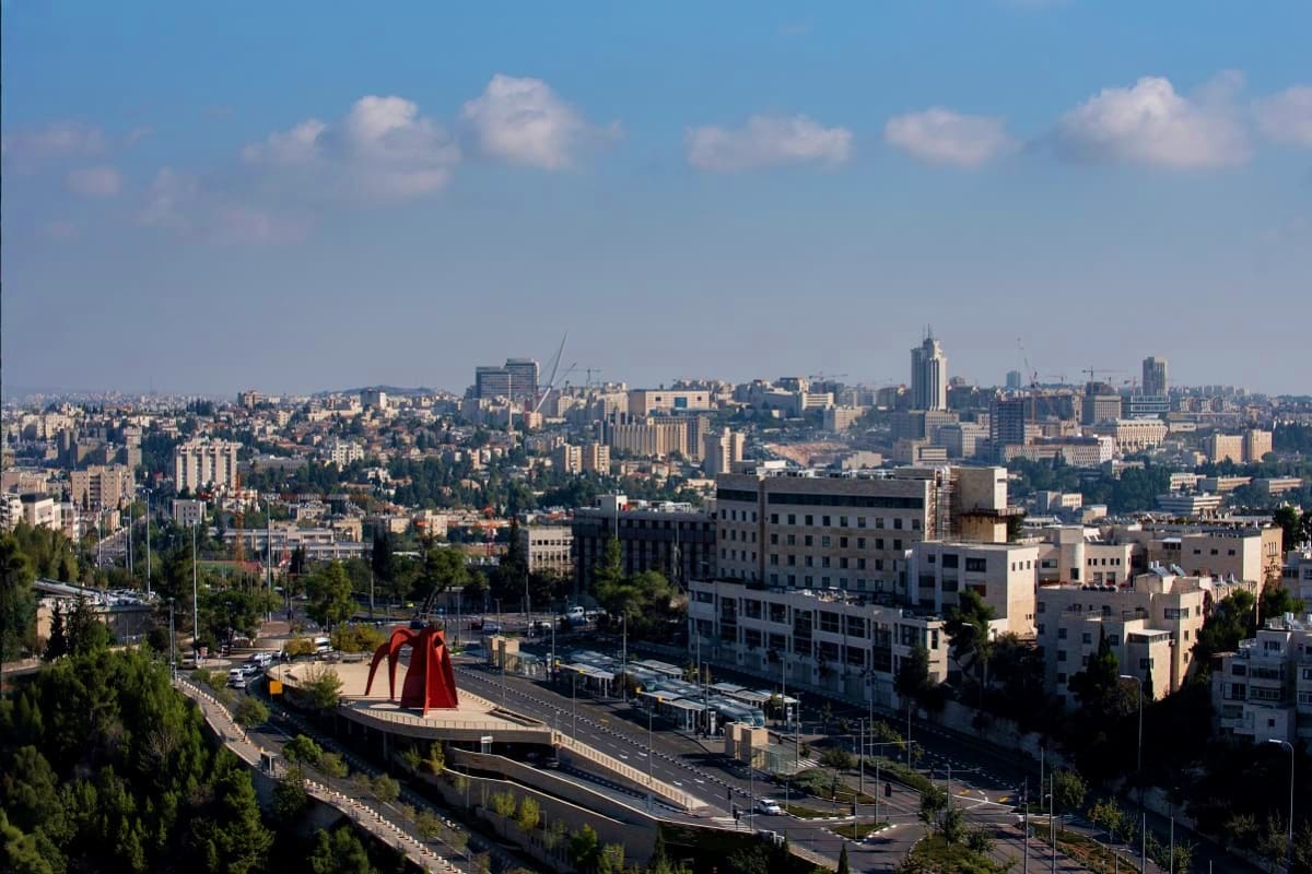 Panoramic cityscape of Amman, Jordan showing modern skyline, red Alexander Calatrava sculpture, and dense urban development u