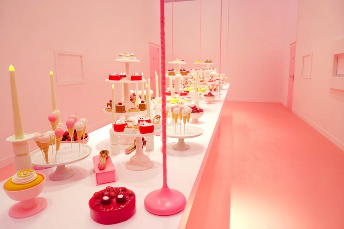 Singapore-Family-Fun-Package Pink-themed dessert display with tiered stands holding cupcakes, pastries, ice cream cones, and decorative items arranged in