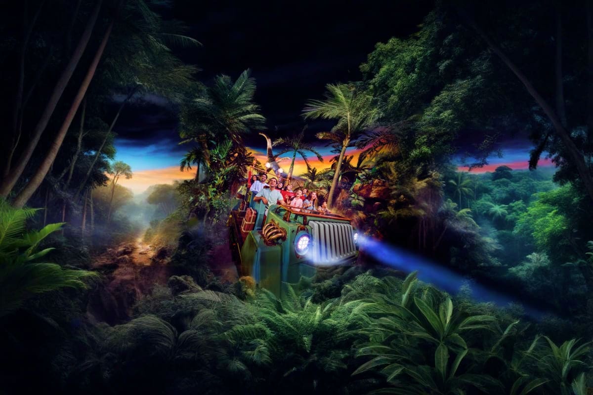 Jungle Adventure ride with passengers in green jeep driving through lush tropical forest with sunset sky and palm trees