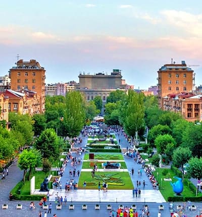 Aerial view of Republic Square in Yerevan with fountains, green spaces, and surrounding Soviet-era buildings at dusk