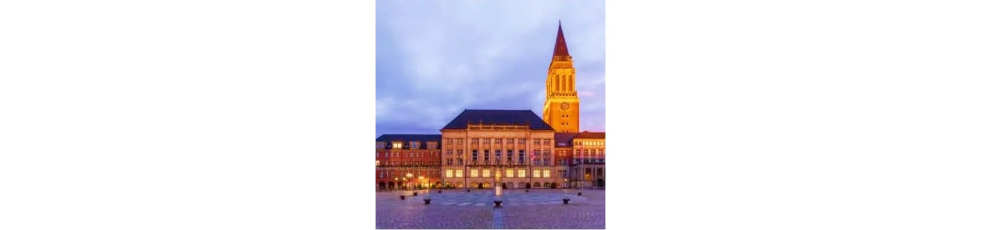 Historic Kiel city square at dusk with illuminated town hall and church spire, Germany