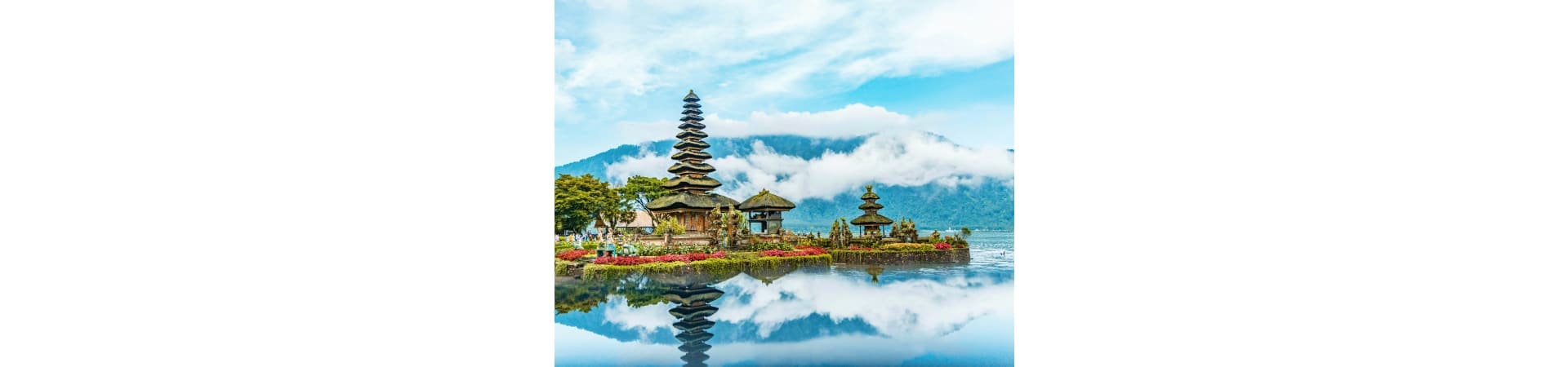 Pura Ulun Danu Bratan temple with tiered pagoda reflected in calm lake water, mountains and clouds in background, Bali