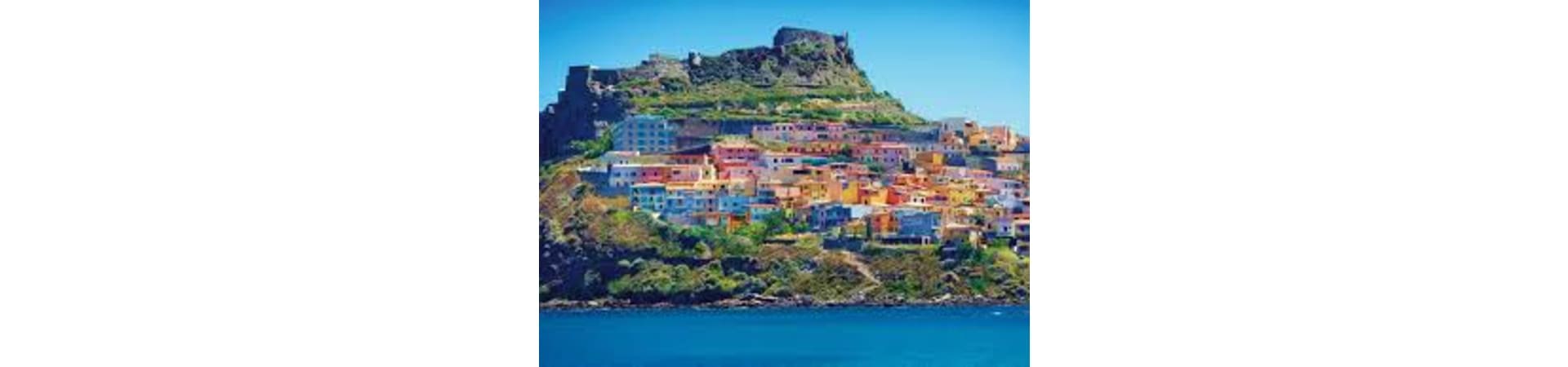 Colorful hillside village with castle ruins overlooking blue sea in Sardinia, Italy