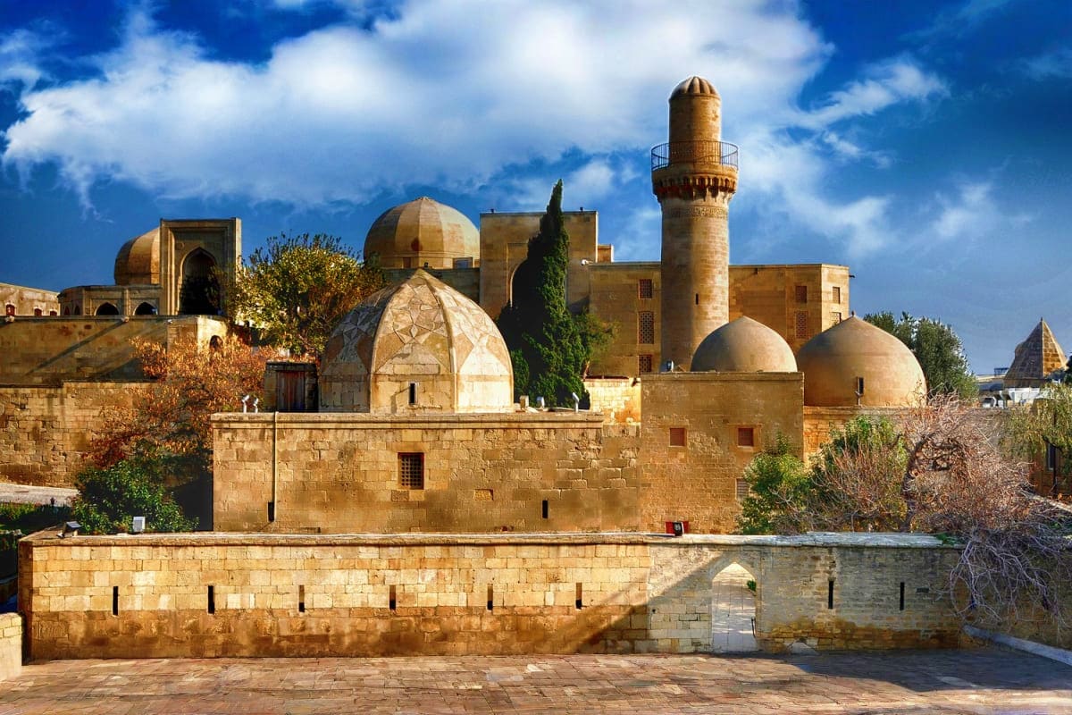 Baku city tour Historic Islamic mosque complex with golden domes and minaret in Old City Baku, Azerbaijan, featuring traditional stone archi