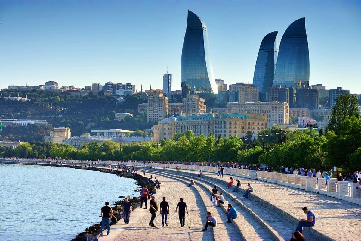 Baku city tour Baku waterfront promenade with Flame Towers skyscrapers, historic buildings, and visitors enjoying the seaside boulevard