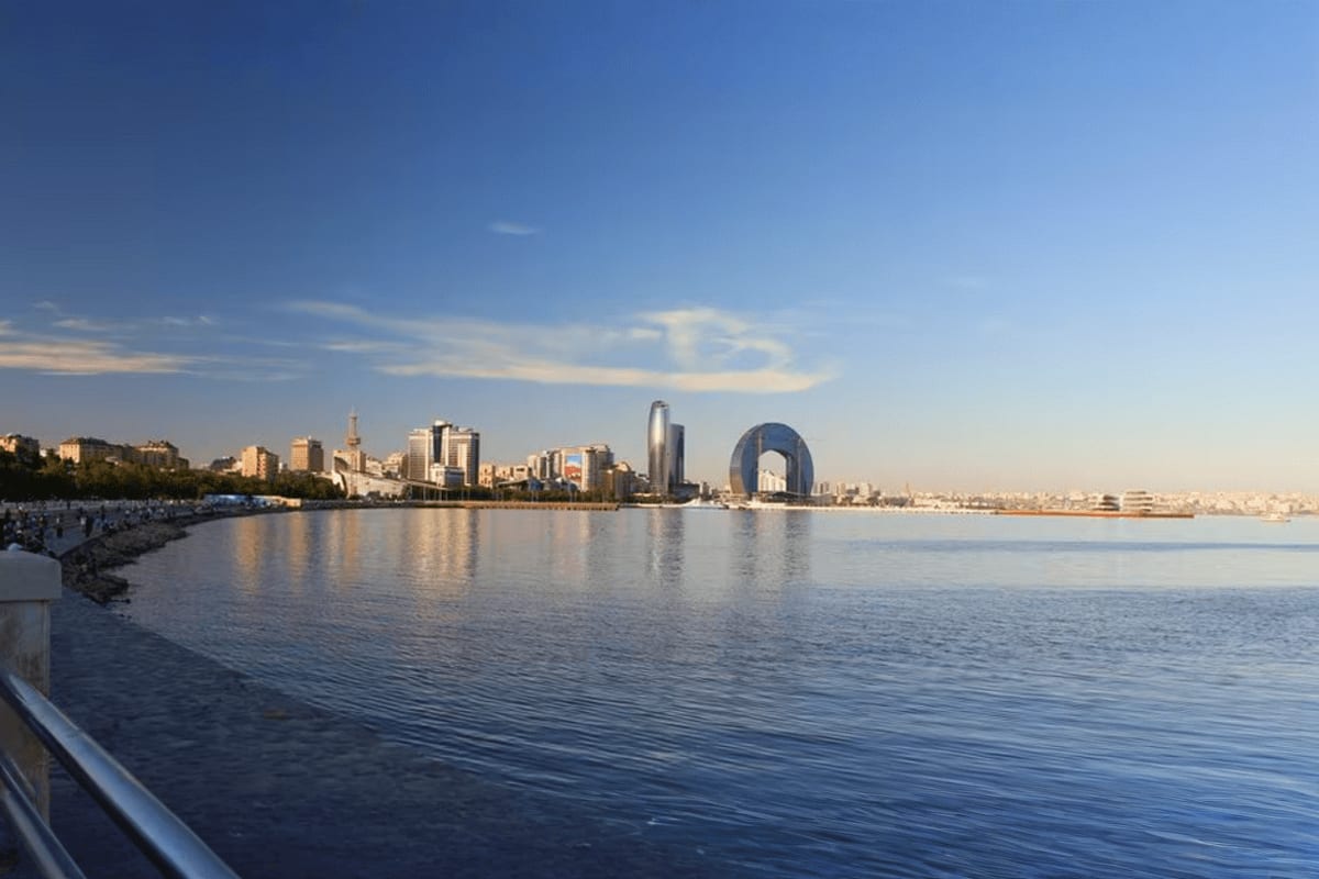 Baku city tour Baku cityscape with modern skyline and Flame Towers reflected in Caspian Sea bay, clear blue sky