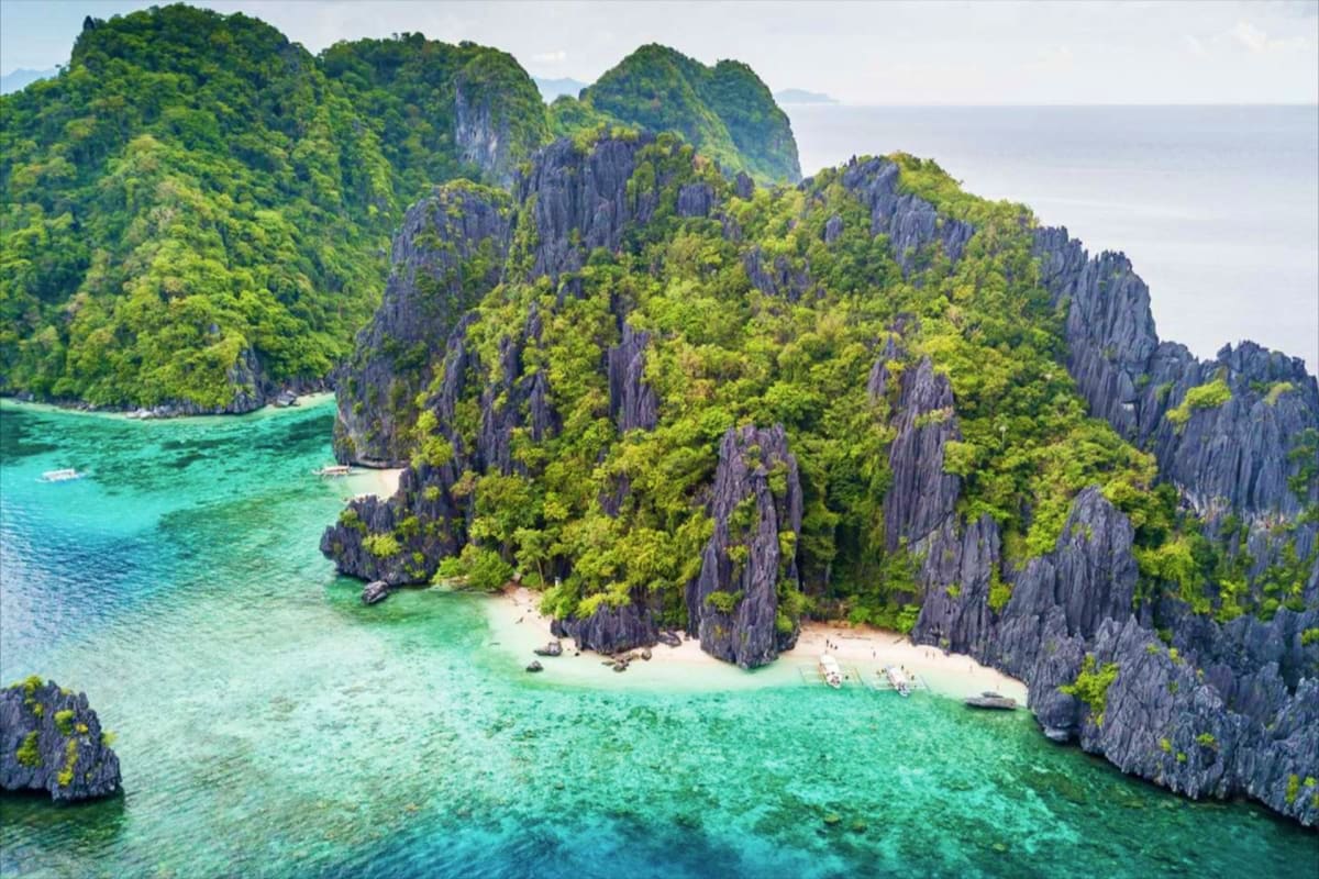 El Nido Island Hopping Tour with Snorkeling Aerial view of limestone cliffs and turquoise lagoon with white sand beach and tourists in clear tropical water, El Nido Pala