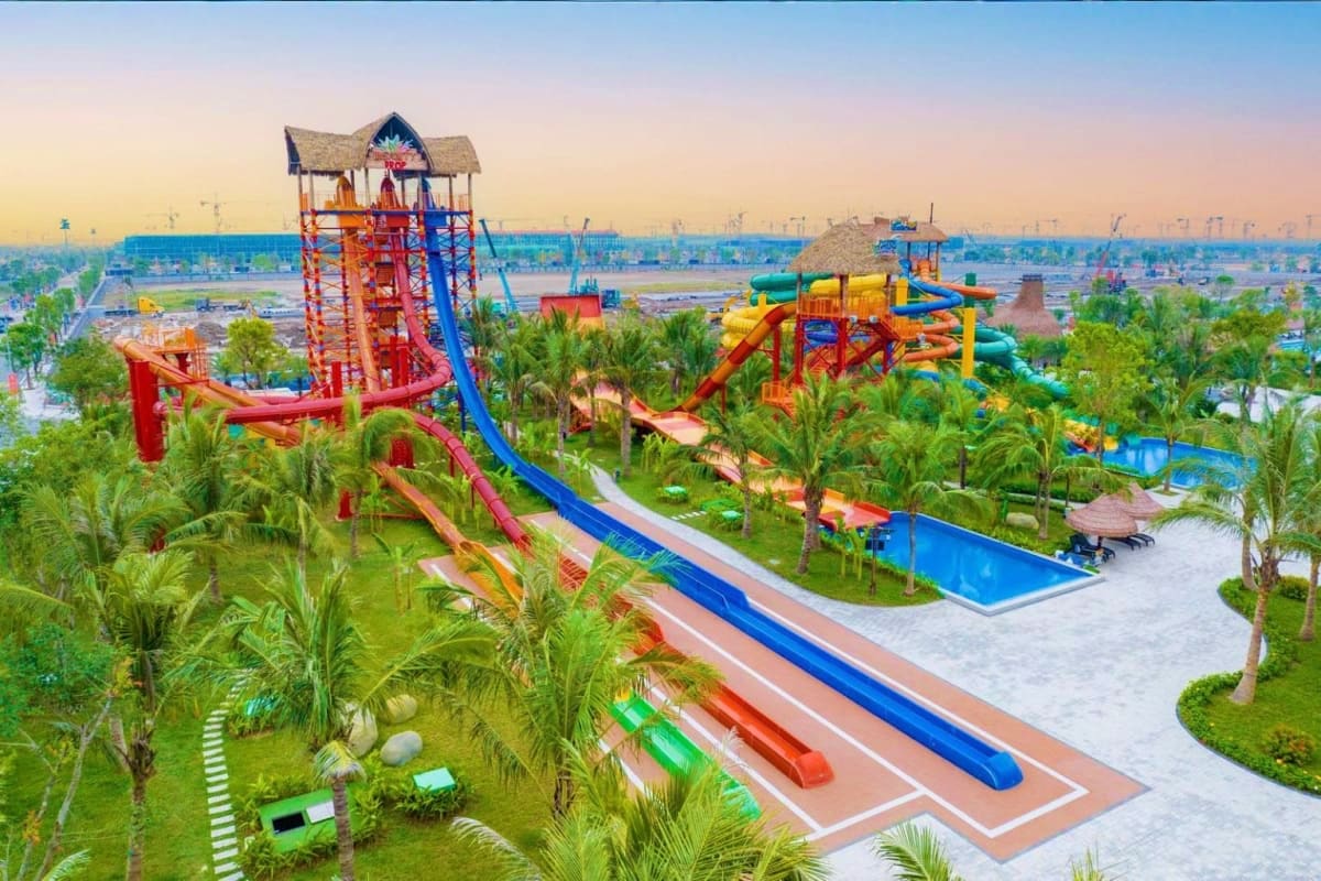 VinWonders Wave Park And Water Park Aerial view of VinWonders Wave Park with colorful water slides, tower attraction, palm trees, and blue pools at sunset