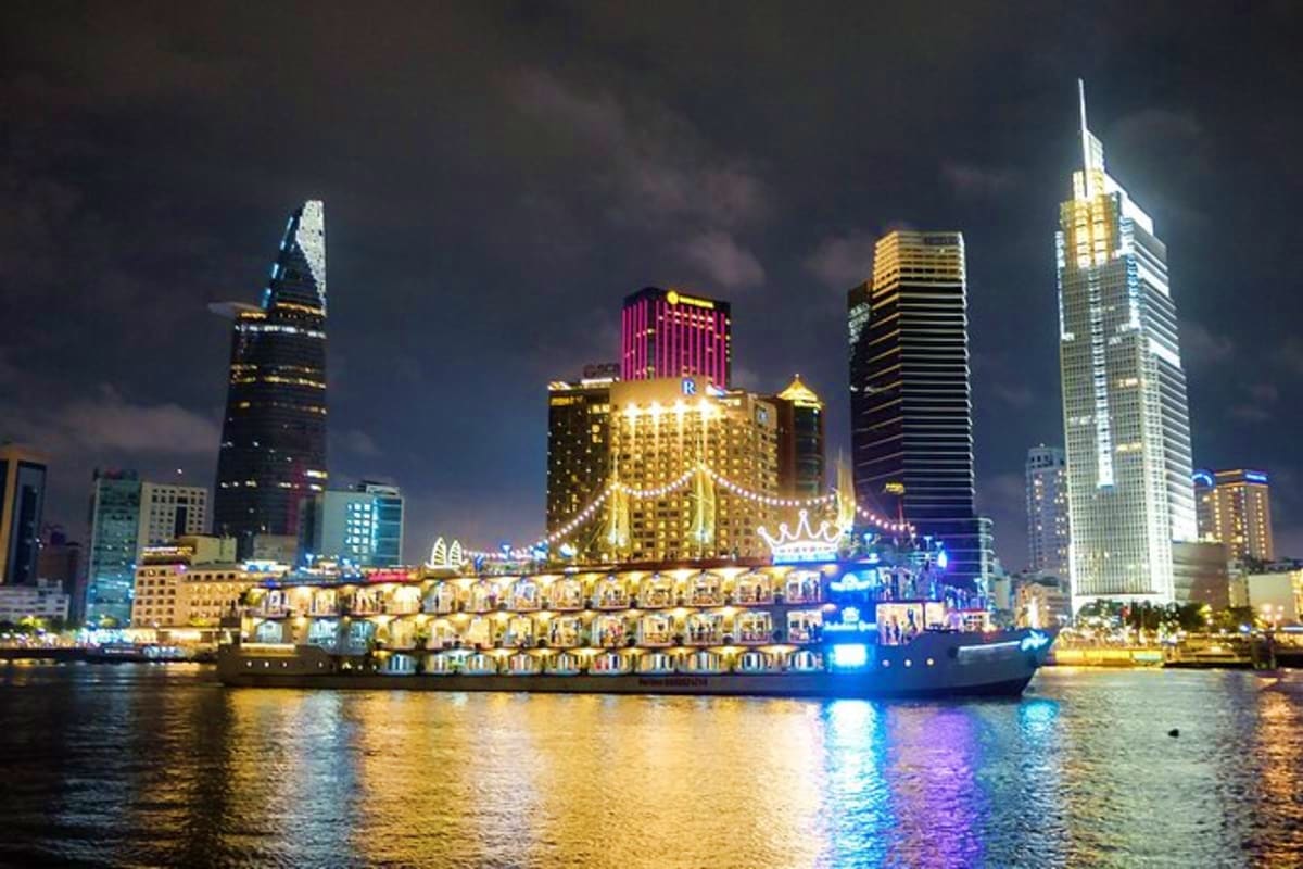 Buffet Dinner Cruise Illuminated dinner cruise ship on river at night with Ho Chi Minh City skyline and lit buildings in background