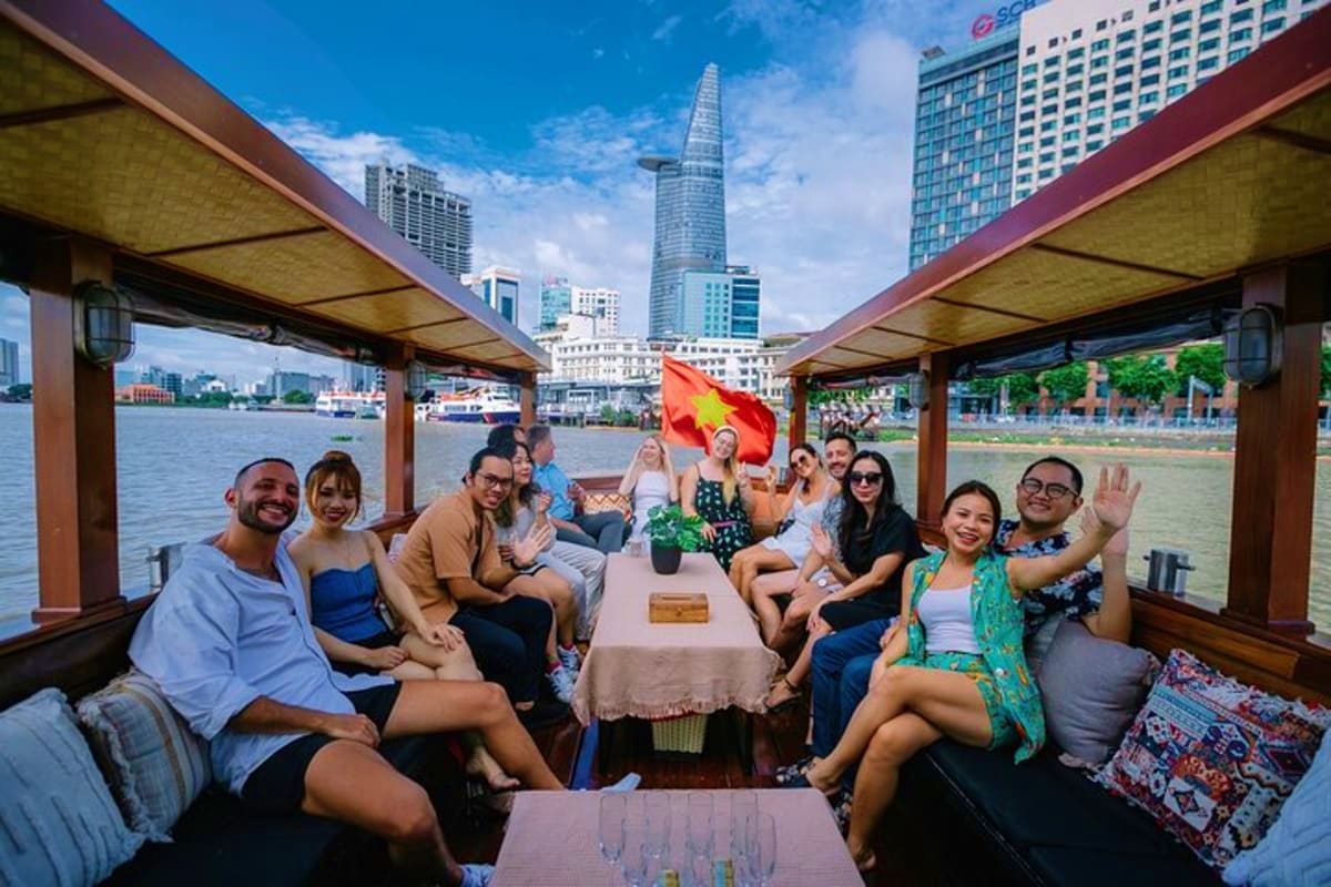 Buffet Dinner Cruise Group of tourists enjoying buffet dinner cruise on Saigon River with Bitexco Financial Tower and city skyline in background