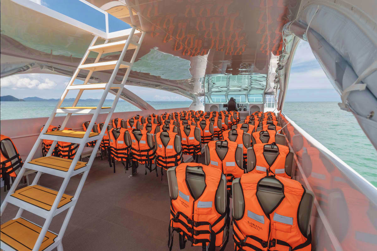 Ferry boat deck with rows of orange life jackets lined up for passengers on Phi Phi Islands day trip tour