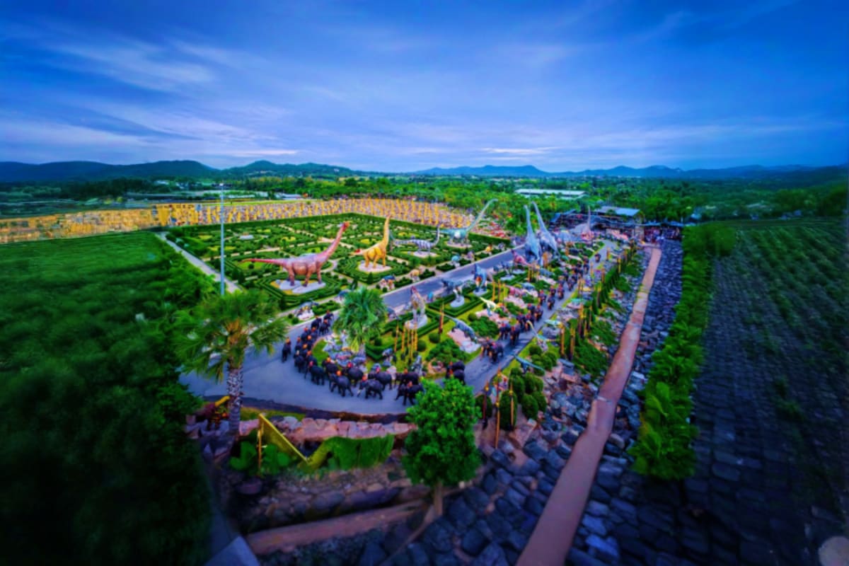 Nong Nooch Tropical Garden Shared Tour Aerial view of Nong Nooch Tropical Garden showing pathways, landscaped gardens, dinosaur sculptures, and green countryside in