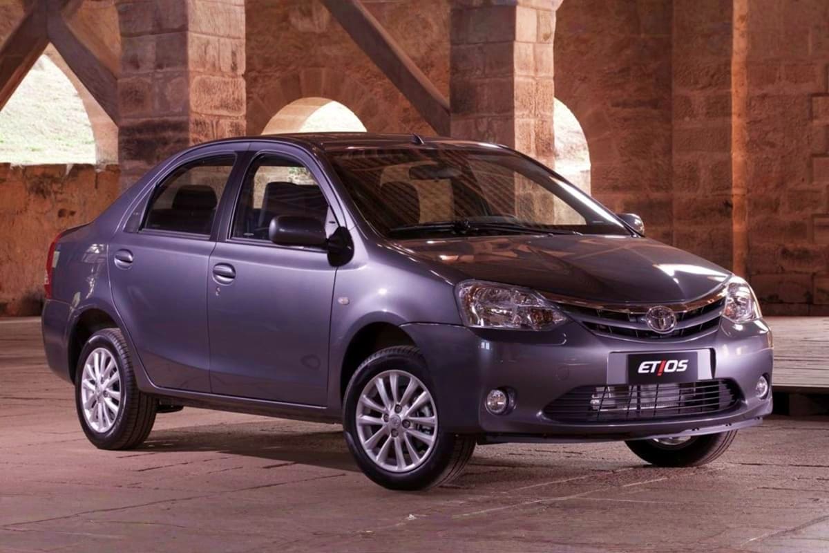 Silver Toyota Etios sedan parked under historic red brick arches at a heritage landmark