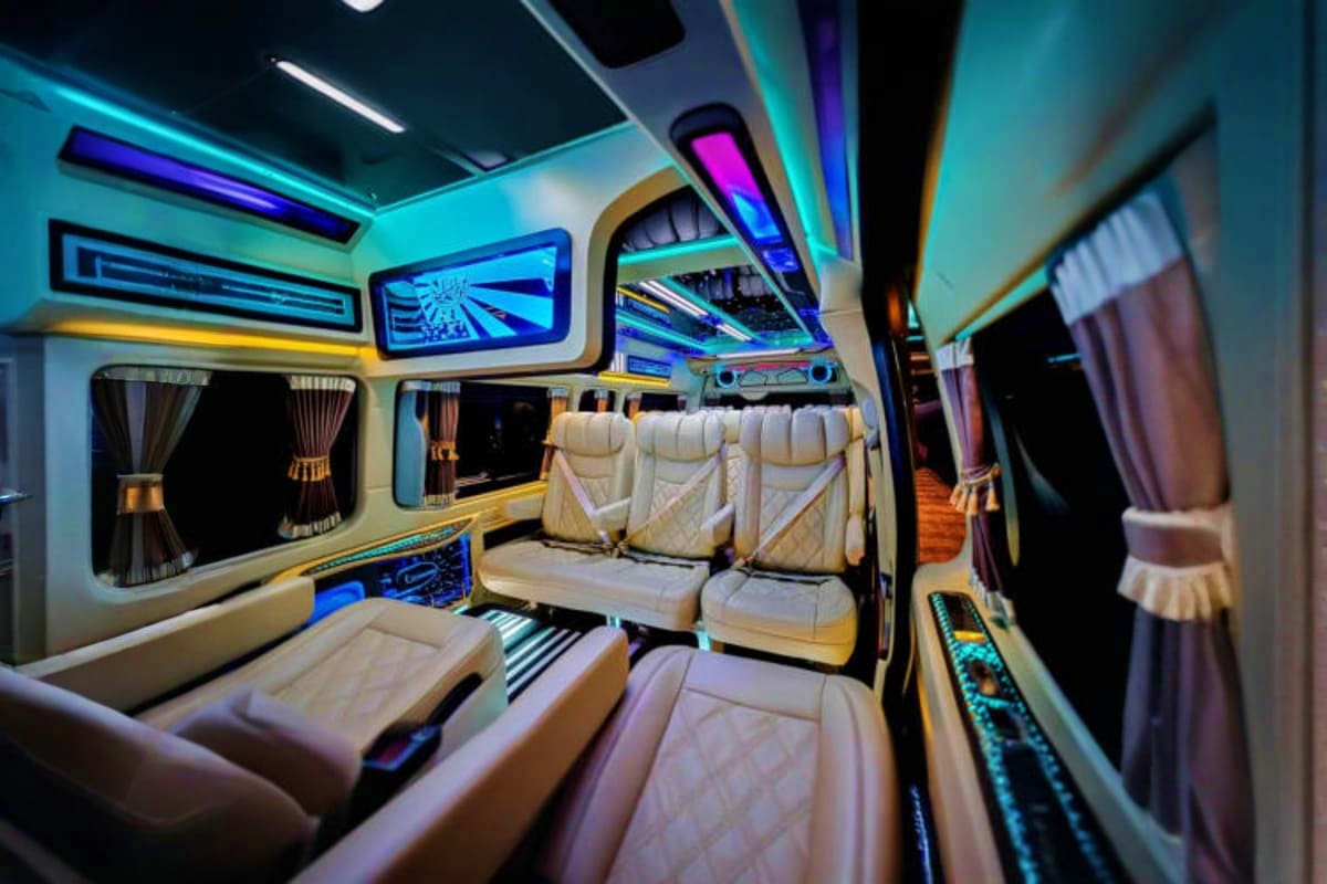 Luxury van interior with cream leather seats, neon blue and purple LED lighting, and modern amenities for airport transfer se