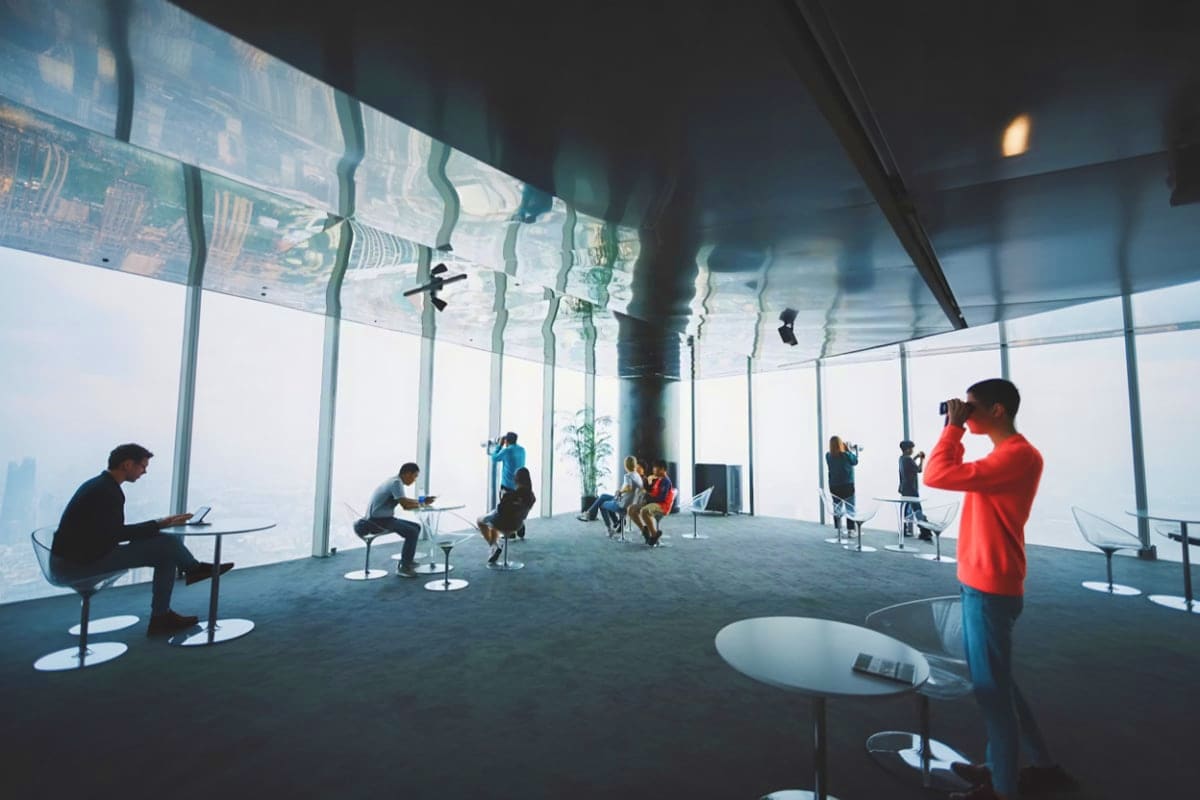 Sky Lotte Observation Deck People visiting Sky Lotte Observation Deck with floor-to-ceiling windows showing cityscape view and reflected ceiling install