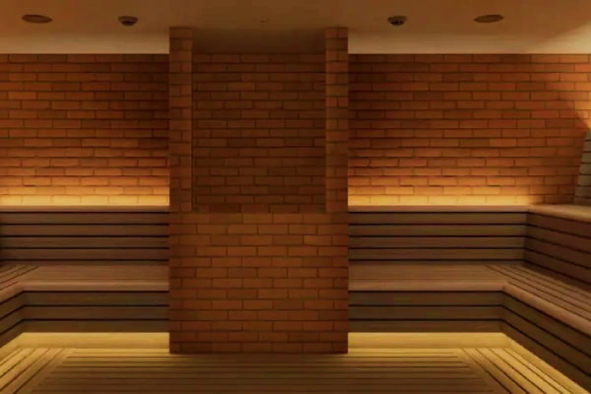 Norwegian Cruise Eastern Caribbean Cruise Interior view of a cruise ship sauna with brick walls, wooden bench seating, and warm ambient lighting from wall fixtures
